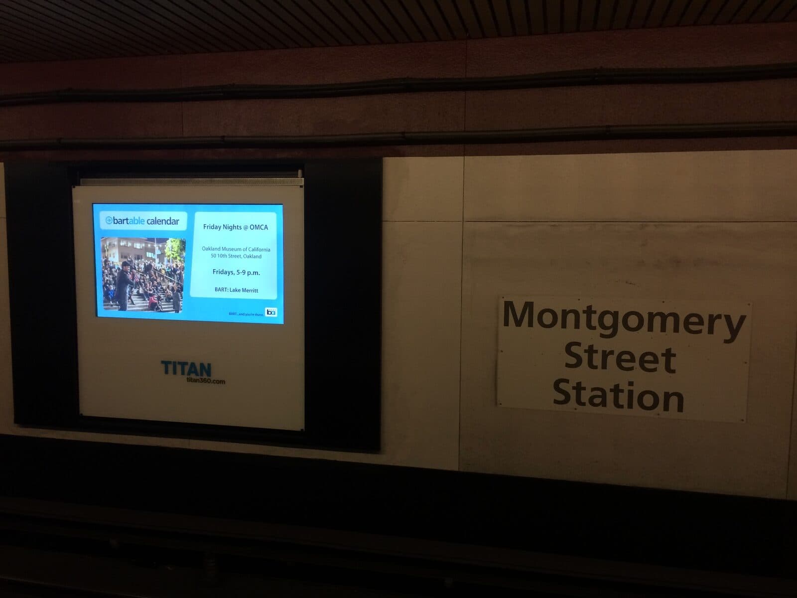 A BARTable calendar promoting Friday Nights at OMCA on a Montgomery Street station display.